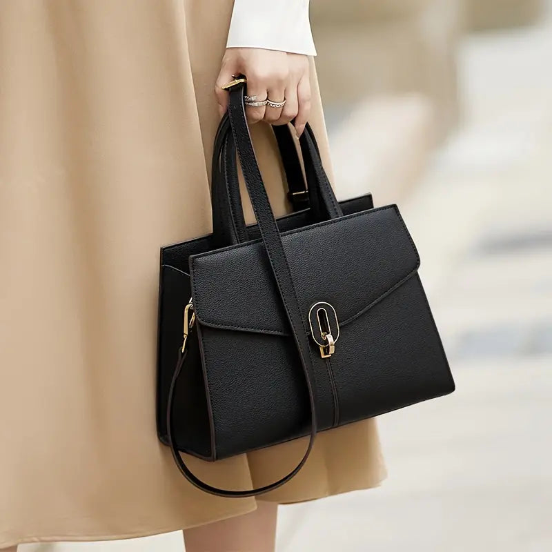 Borsa a mano elegante in pelle nera, design moderno con chiusura dorata, ideale per moda femminile e look professionale. Accessorio di tendenza.