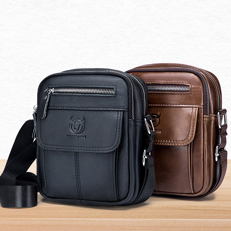 Due borse a tracolla in pelle, una nera e una marrone, con cerniere e logo, su sfondo bianco. Accessori moda uomo eleganti e pratici.
