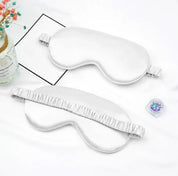 Maschera per dormire in seta bianca su sfondo bianco, con elastico arricciato. Accessorio per il sonno, relax, benessere.
