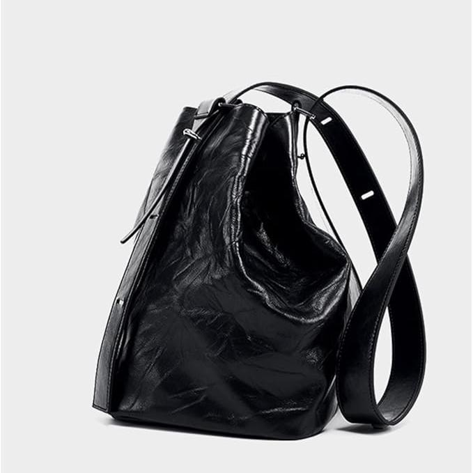 Borsa a secchiello in pelle nera lucida con tracolla regolabile, design elegante e moderno, accessorio moda donna, perfetta per ogni occasione.