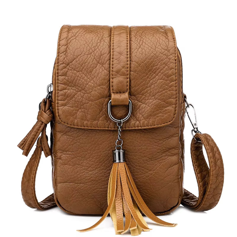 Zaino in pelle marrone con nappina, design elegante e compatto, ideale per moda donna. Perfetto per shopping e viaggi urbani.