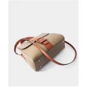 Borsa a tracolla in pelle beige e marrone con fibbia decorativa, design elegante e moderno, accessorio moda donna, perfetta per ogni occasione.