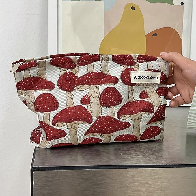 Borsa a mano con stampa di funghi rossi, design originale, su tavolo moderno. Accessorio moda, stile unico, perfetto per look autunnali.