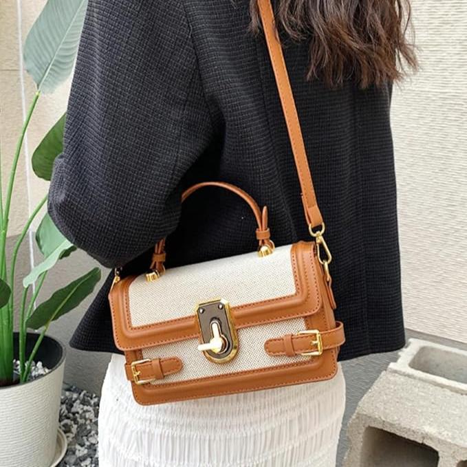 Donna con borsa a tracolla in pelle marrone e tessuto beige, design elegante, chiusura dorata, moda femminile, accessorio di tendenza.