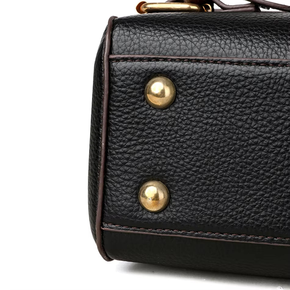 Borsa in pelle nera con dettagli in metallo dorato, texture granulosa, design elegante e moderno, perfetta per moda e accessori di lusso.