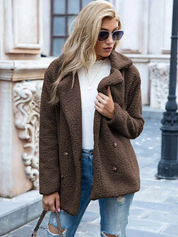 Donna con cappotto in pelliccia sintetica marrone, occhiali da sole, jeans strappati, maglia bianca; moda autunnale urbana elegante.