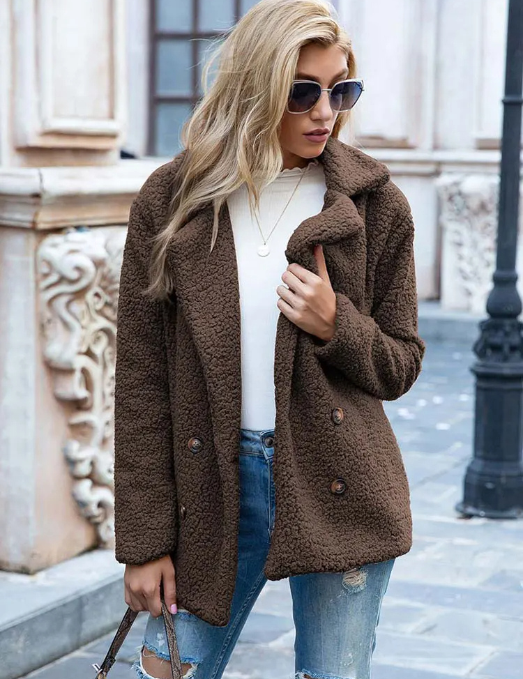 Donna con cappotto in pelliccia sintetica marrone, occhiali da sole, jeans strappati, maglia bianca; moda autunnale urbana elegante.