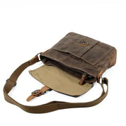 Borsa a tracolla in tela marrone aperta, con tasca frontale e cinghia regolabile. Design vintage, ideale per uomo e donna. Accessorio moda casual.