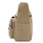 Zaino in tela beige, vista laterale, con tasche multiple e cerniere. Design casual, ideale per viaggi, scuola e uso quotidiano.