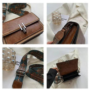 Borsa a tracolla in pelle marrone con fibbia argentata, dettagli borchiati, tracolla regolabile con motivo etnico, su sfondo bianco elegante.