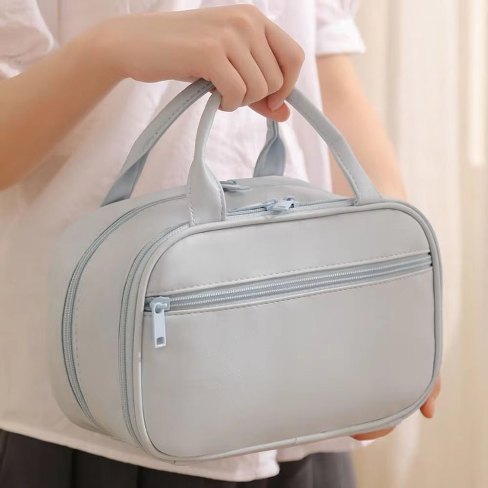 Borsa da toilette grigia con doppia cerniera, manici resistenti, design elegante e compatto. Ideale per viaggi e organizzazione accessori bagno.