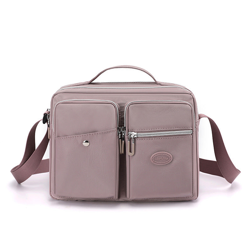 Borsa a tracolla rosa in pelle sintetica con tasche multiple e cerniere, design elegante e pratico, ideale per donna, moda e accessori.