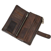 Portafoglio in pelle marrone aperto con scomparti per carte, tasca con cerniera e chiusura a bottone. Accessorio elegante e funzionale per uomo.