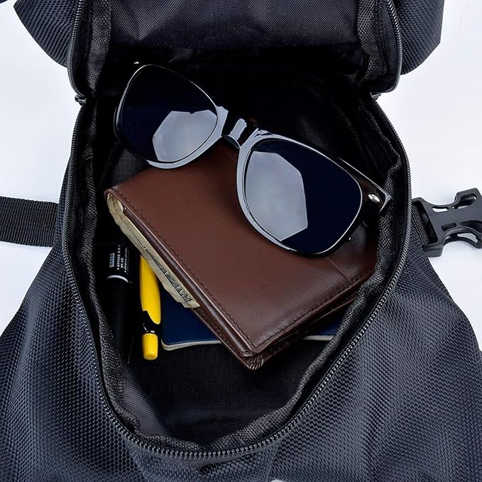 Occhiali da sole neri, portafoglio in pelle marrone e penne in uno zaino nero aperto. Accessori moda, viaggio, organizzazione.