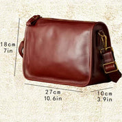 Borsa a tracolla in pelle marrone, dimensioni 27x18x10 cm, con tracolla regolabile e fibbie dorate. Elegante accessorio moda per uomo e donna.