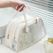 Borsa da viaggio bianca con doppia cerniera, tasca in rete e manici, ideale per organizzare articoli da toeletta. Design elegante e funzionale.