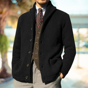 Giacca cardigan uomo nera elegante, abbinata a gilet marrone e cravatta a fantasia, perfetta per look autunnali e invernali. Moda maschile sofisticata.