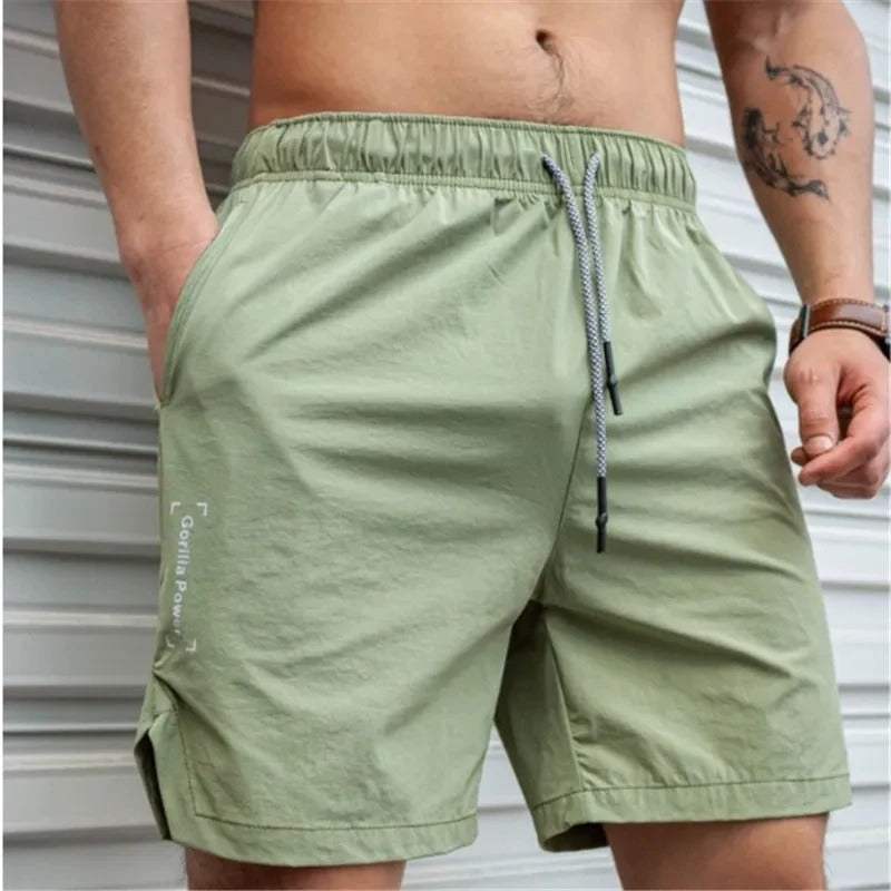 Pantaloncini sportivi uomo verde chiaro, elastico in vita, tasche laterali, cordoncino regolabile, ideale per fitness e tempo libero.