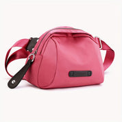 Borsa a tracolla rosa in tessuto, design moderno, con cerniera e dettagli in pelle nera. Accessorio moda donna, elegante e pratico.
