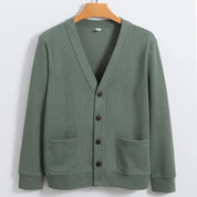 Cardigan verde salvia da uomo in cotone, con scollo a V, bottoni frontali e tasche applicate. Elegante e casual, perfetto per ogni stagione.