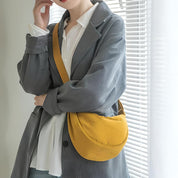 Donna con borsa a tracolla gialla, giacca grigia e camicia bianca. Moda casual, accessori femminili, stile urbano.