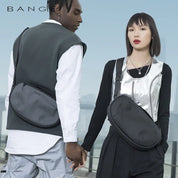 Due persone con borse a tracolla nere Bange, abbigliamento moderno e urbano, sfondo urbano. Moda contemporanea, accessori unisex eleganti.