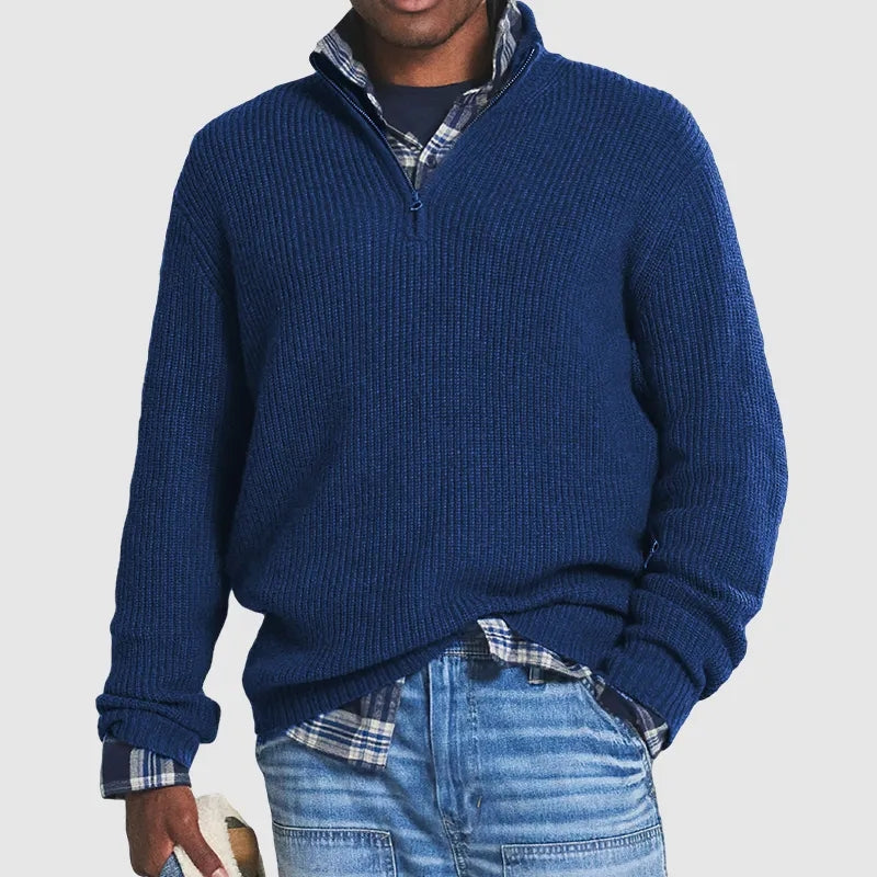 Maglione blu a collo alto con zip, indossato sopra camicia a quadri blu e jeans. Look casual maschile, moda autunnale, abbigliamento uomo.