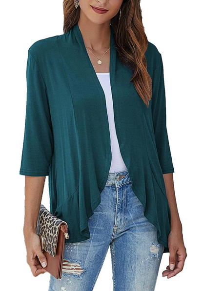 Donna con cardigan verde scuro, jeans strappati e pochette leopardata. Moda casual femminile, abbigliamento autunnale elegante.