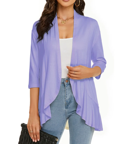 Donna con cardigan aperto viola, maniche a tre quarti, indossa top bianco e jeans. Accessori: collana oro, borsa nera. Moda casual elegante.