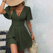 Abito estivo verde oliva con scollo a V e maniche corte a volant, indossato da donna con cappello di paglia. Elegante e casual, perfetto per l'estate.
