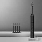 Spazzolino elettrico nero con testine di ricambio su sfondo grigio. Design moderno, tecnologia avanzata per igiene orale ottimale.