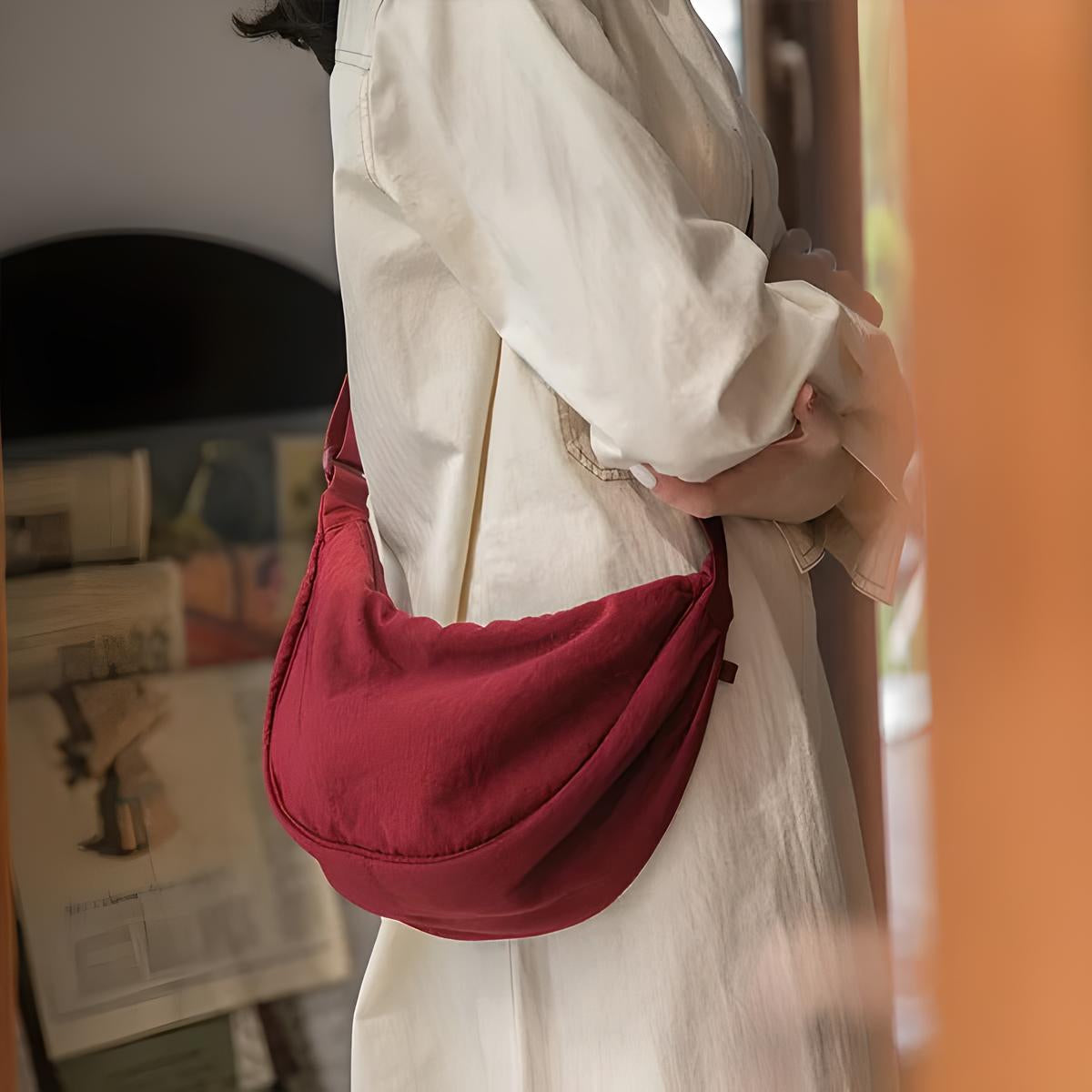 Donna con borsa a tracolla rossa in tessuto, indossa abito bianco. Moda casual, accessorio elegante, stile minimalista.