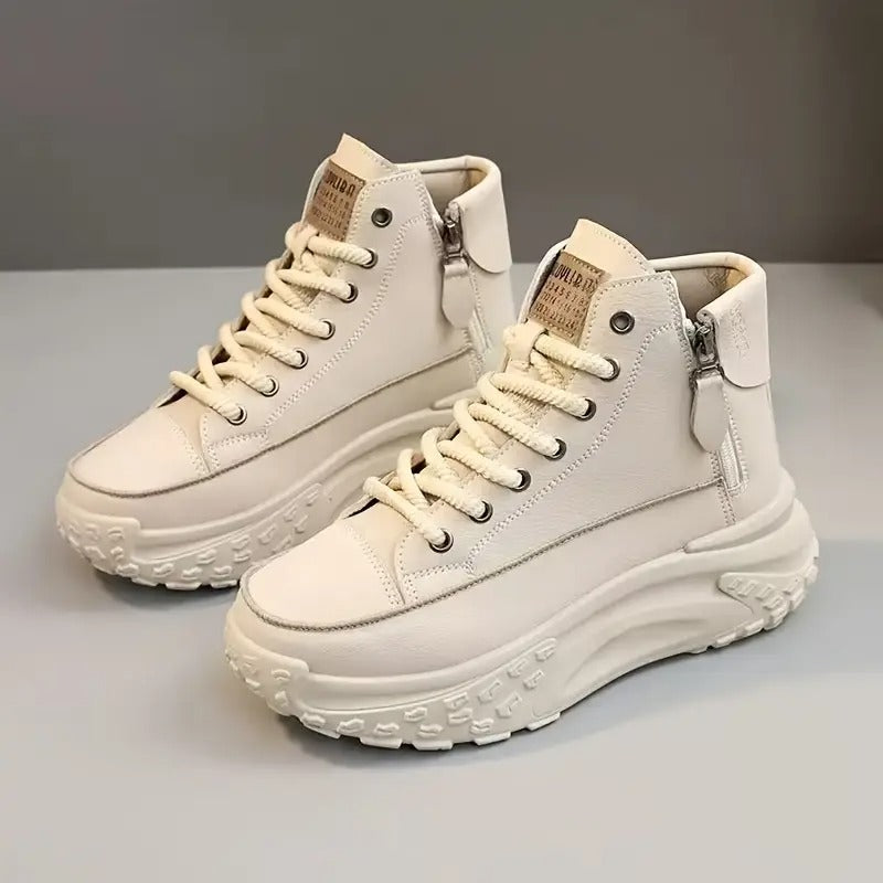 Scarpe da ginnastica alte bianche con suola spessa, lacci e cerniera laterale. Design moderno e casual, ideali per moda urbana e comfort quotidiano.