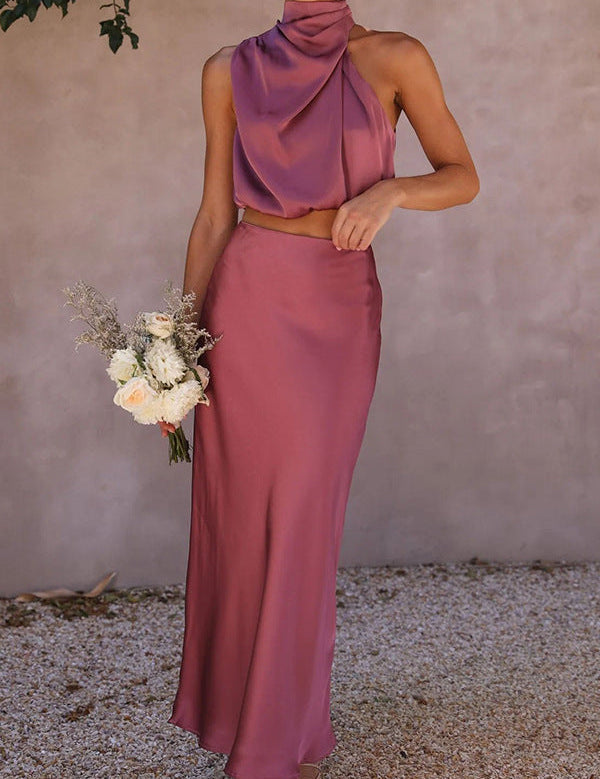 Abito da cerimonia elegante in raso rosa, top senza maniche e gonna lunga, bouquet di fiori bianchi, moda donna, abbigliamento formale.