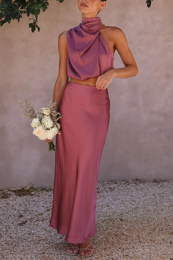 Abito da cerimonia elegante in raso rosa, top senza maniche con collo alto e gonna lunga. Donna con bouquet di fiori bianchi.