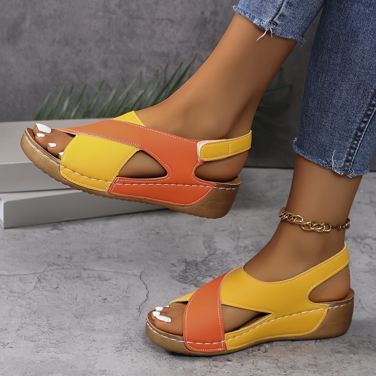 Sandali donna estivi in pelle giallo-arancione, tacco basso, design aperto, abbinati a jeans. Scarpe comode e alla moda per look casual.