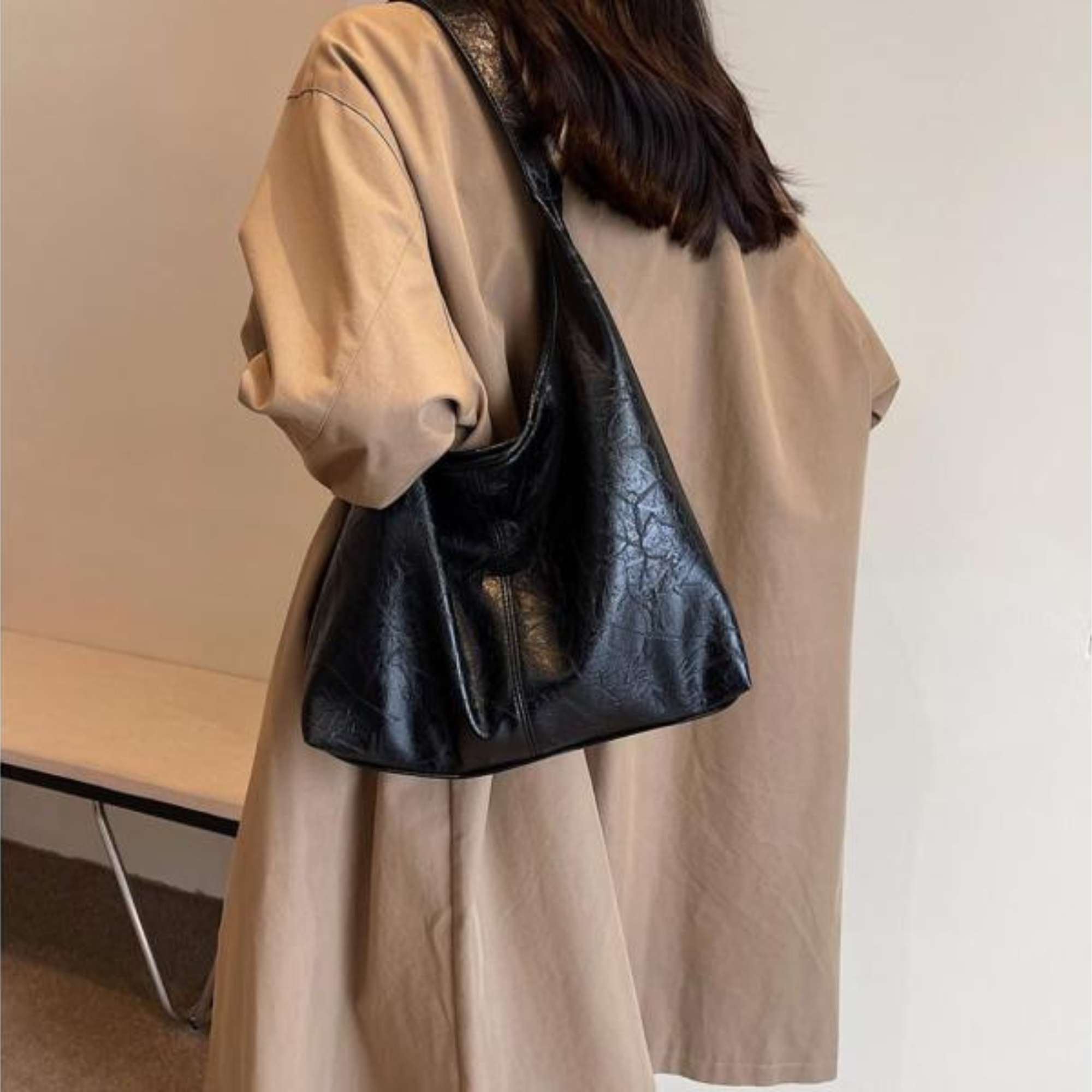 Donna con cappotto beige e borsa a tracolla nera in pelle, moda autunno, stile casual chic, accessori eleganti, tendenze 2023.