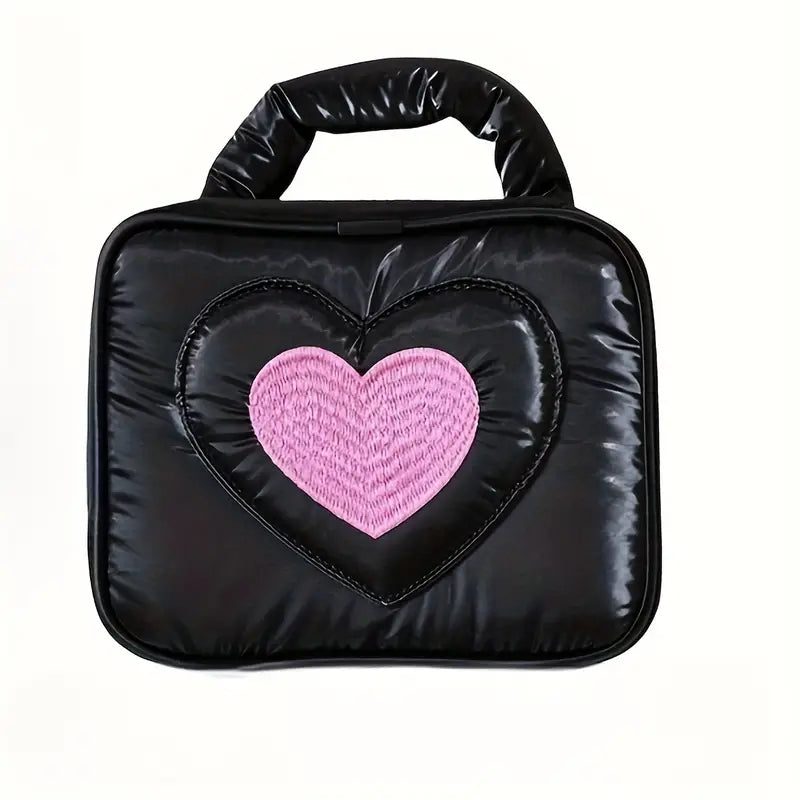 Borsa a mano nera con cuore rosa centrale, design moderno, ideale per moda femminile. Accessorio elegante e versatile per ogni occasione.