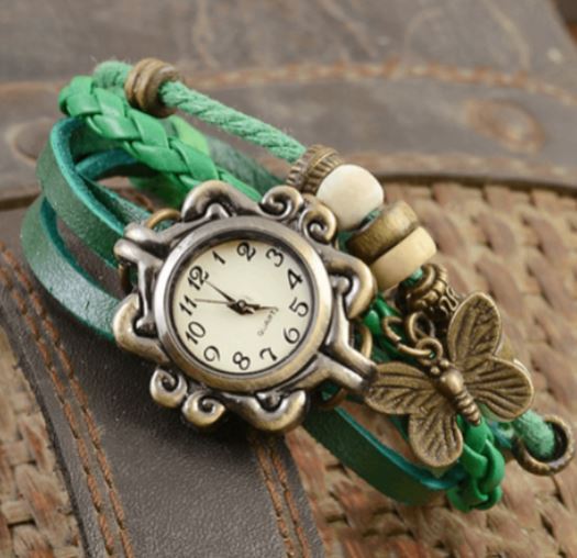 Orologio vintage con cinturino intrecciato verde, decorato con ciondolo a farfalla e perline. Design retrò, accessorio moda elegante.