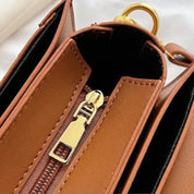 Borsa a tracolla in pelle marrone con cerniera dorata, design elegante e moderno, accessorio moda donna, ideale per ogni occasione.