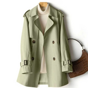 Cappotto trench verde chiaro da donna, doppio petto, con cintura e bottoni, su gruccia. Elegante e versatile per moda autunnale e invernale.