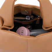 Borsa in pelle marrone aperta, contenente rossetto, specchietto, crema rosa e altri accessori. Elegante e spaziosa, ideale per l'uso quotidiano.