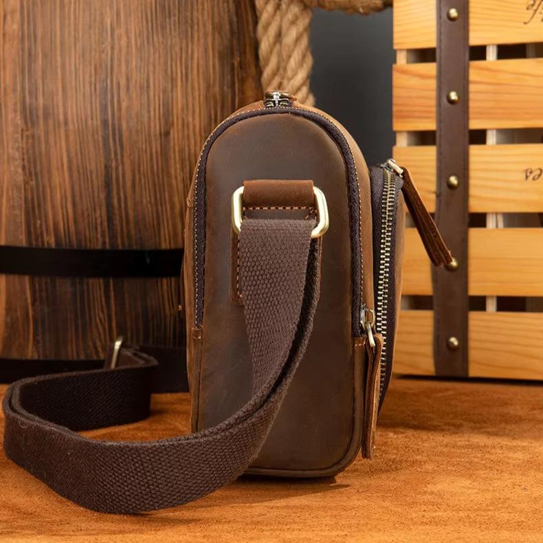 Borsa a tracolla in pelle marrone vintage, design compatto, cerniera robusta, ideale per uomo, accessorio moda elegante e funzionale.