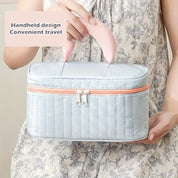 Borsa da viaggio portatile grigia con manico rosa, design elegante, chiusura a zip, ideale per organizzare cosmetici e accessori in viaggio.