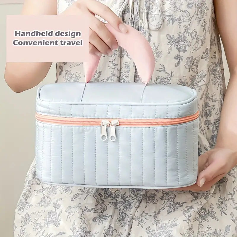 Borsa da viaggio portatile grigia con manico rosa, design elegante, chiusura a zip, ideale per organizzare cosmetici e accessori in viaggio.