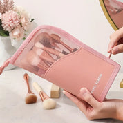 Set di pennelli trucco rosa in custodia a rete, con fiori sullo sfondo. Accessori cosmetici da viaggio, eleganti e pratici per il make-up.