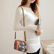 Donna con borsa a tracolla multicolore in pelle, design geometrico, indossa maglia bianca. Accessorio moda femminile elegante e moderno.