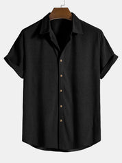 Camicia nera a maniche corte, tessuto a righe sottili, colletto classico, bottoni marroni, stile casual elegante, perfetta per l'estate.