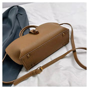 Borsa a tracolla in pelle marrone su sfondo bianco, design elegante e moderno, accessorio moda donna, perfetta per ogni occasione.