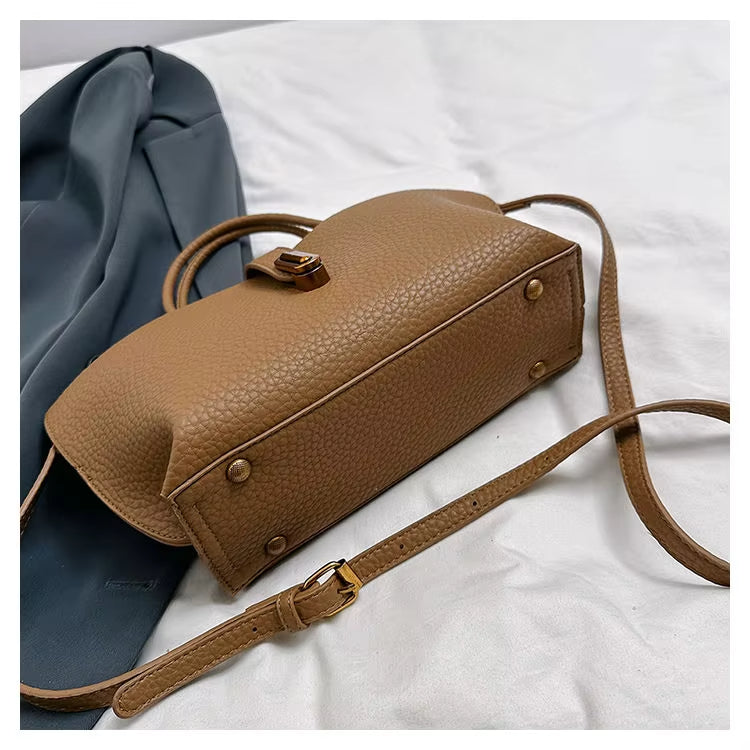 Borsa a tracolla in pelle marrone su sfondo bianco, design elegante e moderno, accessorio moda donna, perfetta per ogni occasione.